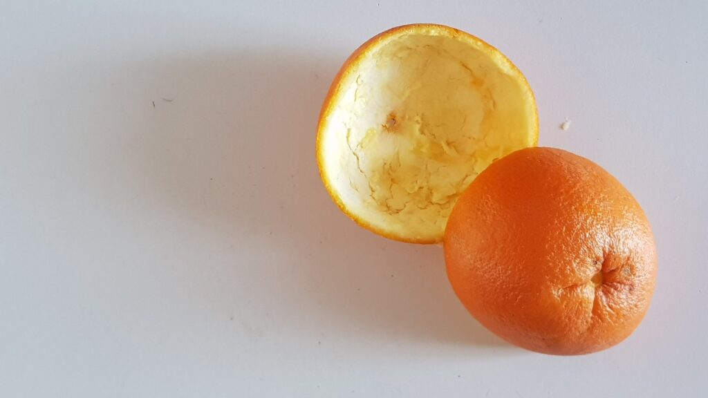 أولا تقشير البرتقال إلى قطعتين متقايستين